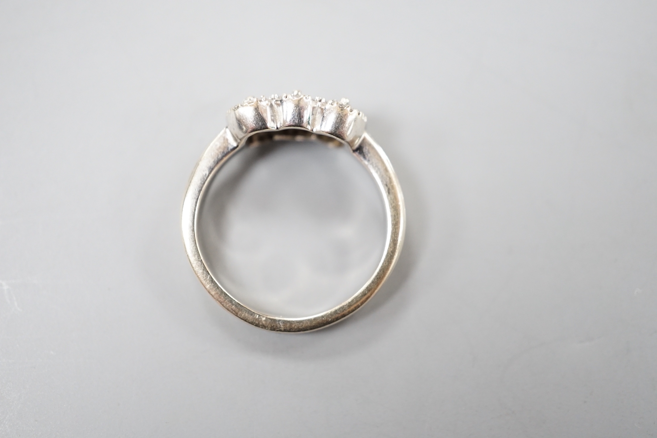 A modern 18ct white gold and diamond set triple cluster ring, size L, gross weight 5.3 grams.